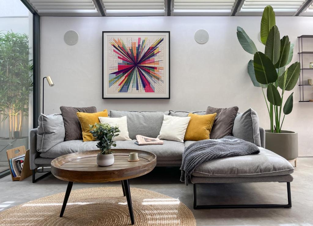 uma sala de estar com um sofá e uma mesa em Luxury Urban Oasis with Garden and Private Studio em Londres