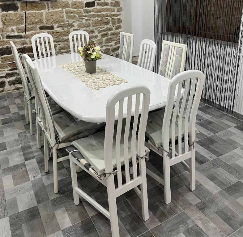 - une table à manger blanche avec des chaises blanches, une table blanche et des chaises dans l'établissement Къща за гости "Холидей - Луковит", à Lukovit