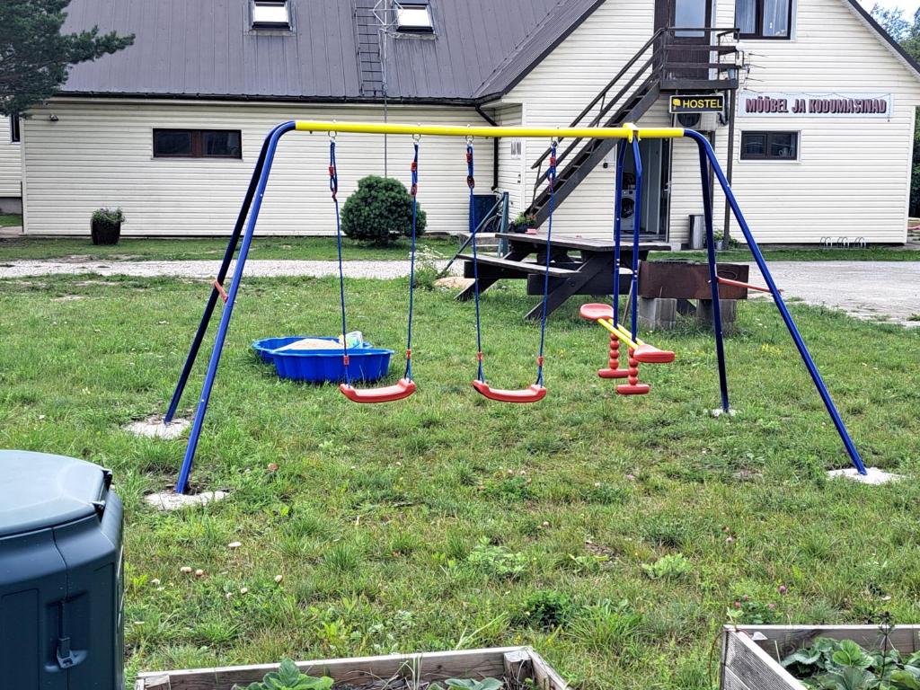 un parque infantil en un patio con columpios en Kullerkupu Hostel, en Kuressaare