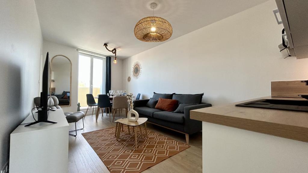 un salon avec un canapé et une table dans l'établissement L'Horizon, à Fort-Mahon-Plage