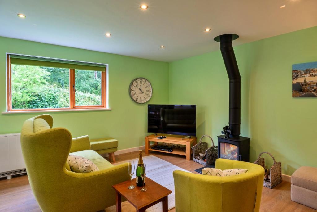 a living room with green walls and a fireplace at Finest Retreats - Skylarks in Boscastle