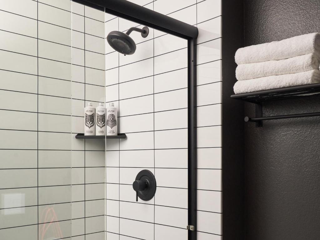 a bathroom with a shower with white tiles at Field Station Joshua Tree in Yucca Valley