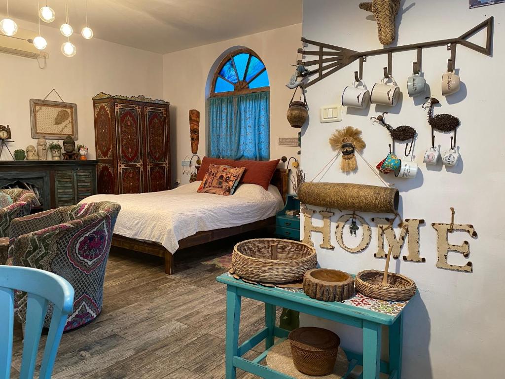 a bedroom with a bed and a table with baskets at Zehava's Zimmer in Ein Gedi