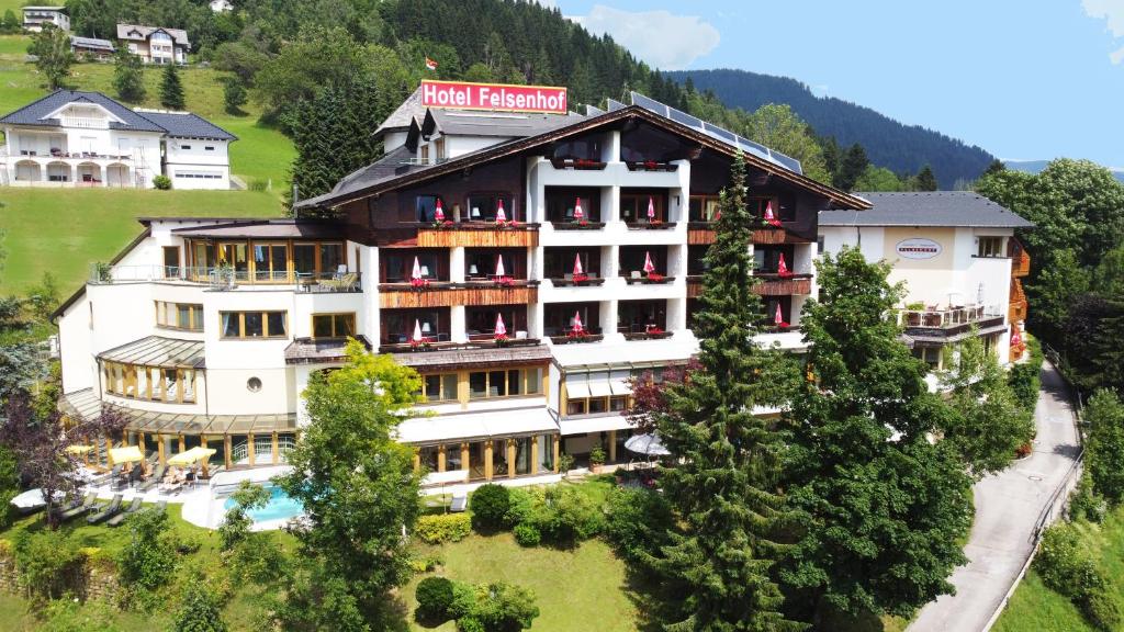 ein Hotel auf einem Hügel mit Bäumen davor in der Unterkunft Wohlfühl & Genusshotel Felsenhof in Bad Kleinkirchheim