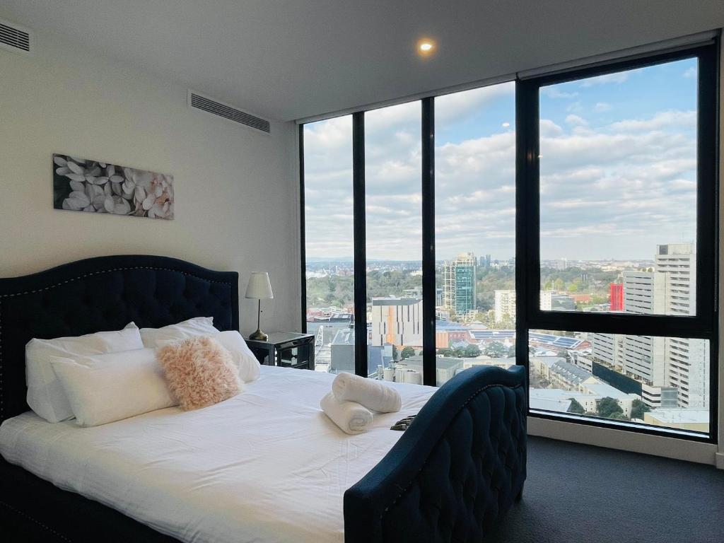 um quarto com uma cama e uma janela grande em Free Parking-Luxurious & Spacious Skyline view Apt em Melbourne