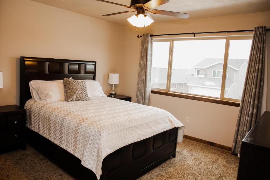 a bedroom with a bed with a ceiling fan and a window at Bridges Bay Vacation Cabin 152 in Arnolds Park