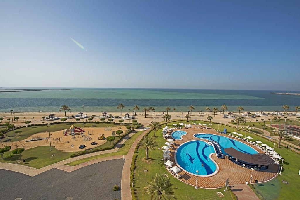 an aerial view of a resort with a swimming pool and the beach at Mirfa Hotel in Al Mirfa