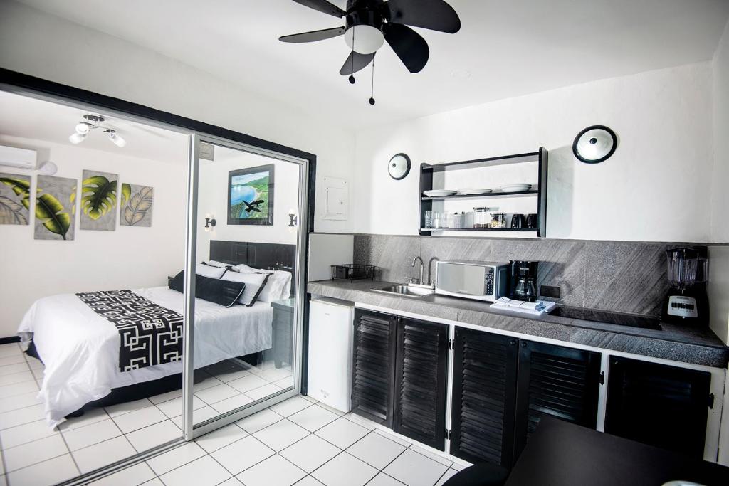 a bedroom with a bed and a kitchen with a microwave at Villa Roca Boutique Resort & Suites - ADULT ONLY in Manuel Antonio