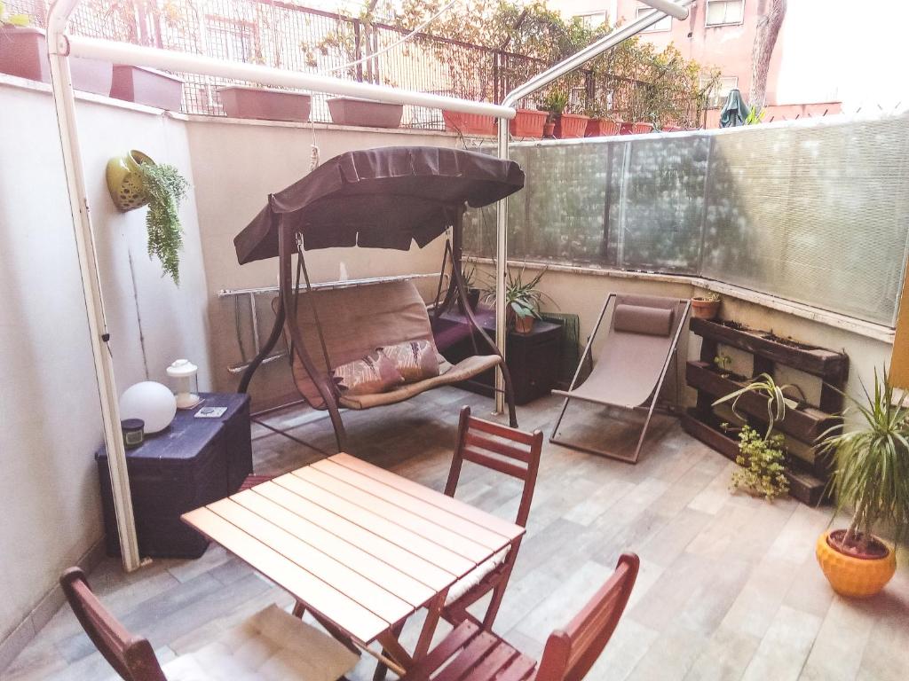patio con tavolo, sedie e ombrellone di Cozy flat with terrace at Trastevere train station a Roma