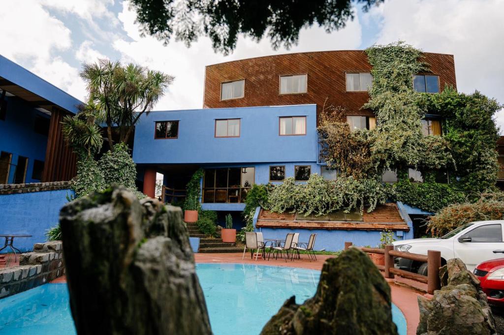 a building with a swimming pool in front of a building at Hotel Tierra del Sur in Temuco