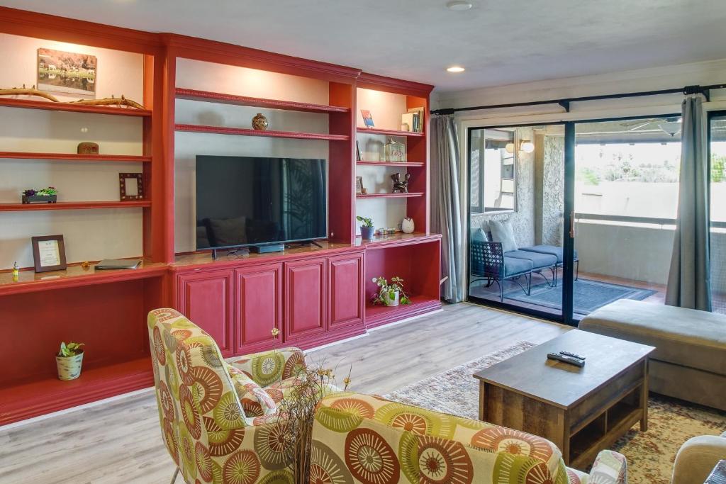 Il comprend un salon doté de murs rouges et d'une télévision à écran plat. dans l'établissement Scottsdale Condo with Pool, 1 Mi to Old Town!, à Scottsdale