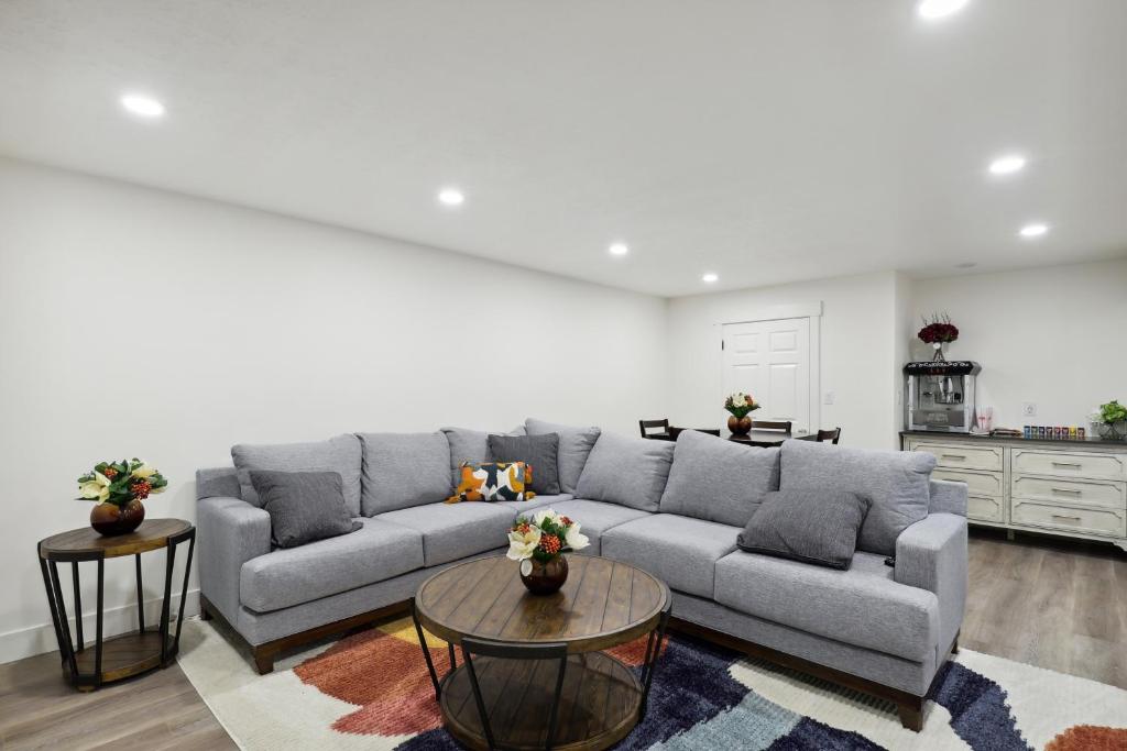 a living room with a gray couch and two tables at Family-Friendly Provo Vacation Rental Near BYU! in Provo
