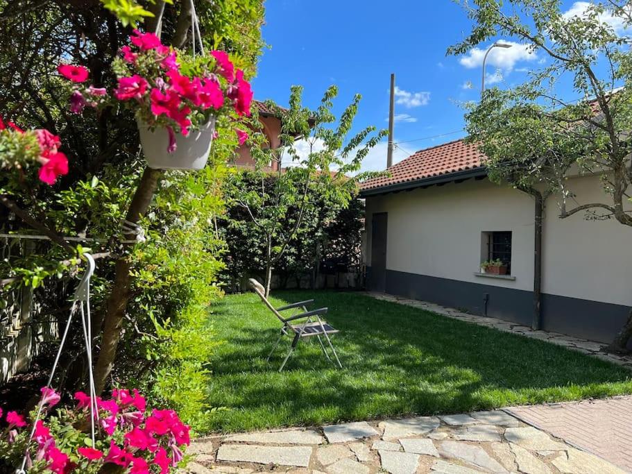 einen Hof mit rosa Blumen und einem Haus in der Unterkunft Villa Perosi in Vigevano