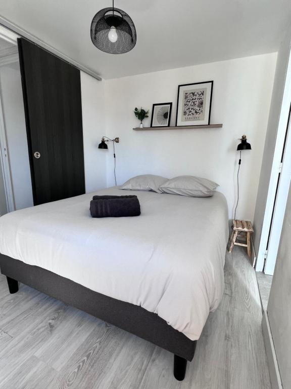 a bedroom with a large bed with white sheets at Le gargantua, appartement à 500m du château in Chinon