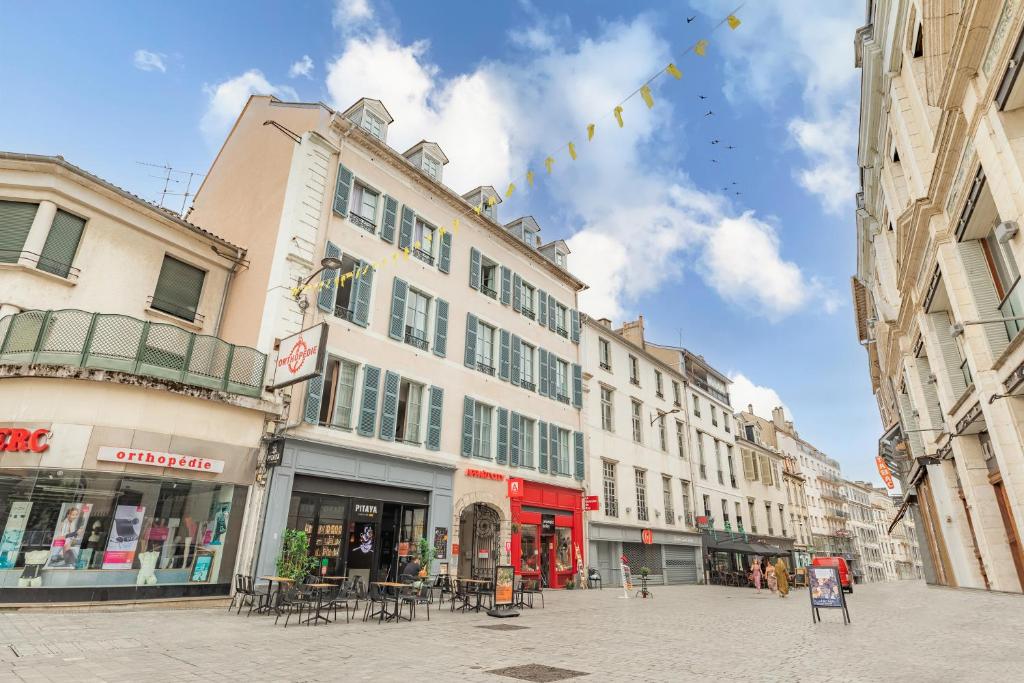 a city street with buildings and tables and chairs at Appart&#39;City Confort Pau Centre in Pau