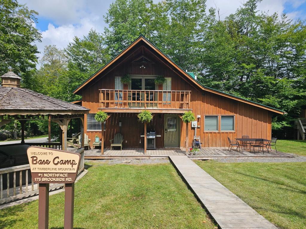 a log cabin with a sign in front of it at Base Camp in Cortland