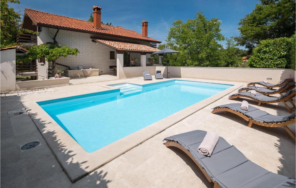 a swimming pool with chairs and a house at 4 Bedroom Gorgeous Home In Katun Lindarski in Katun Lindarski
