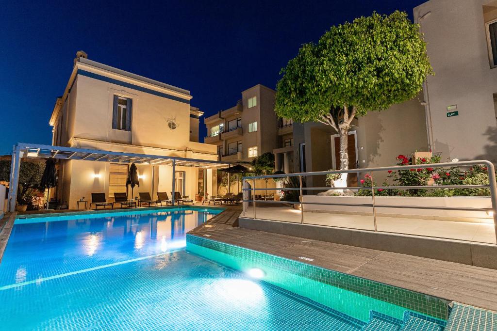 a swimming pool in front of a building at night at Creta Elena in Chania