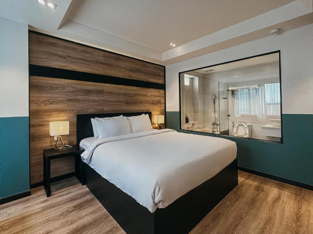 a bedroom with a large bed and a large mirror at The Chill Suites - City Center in Ho Chi Minh City