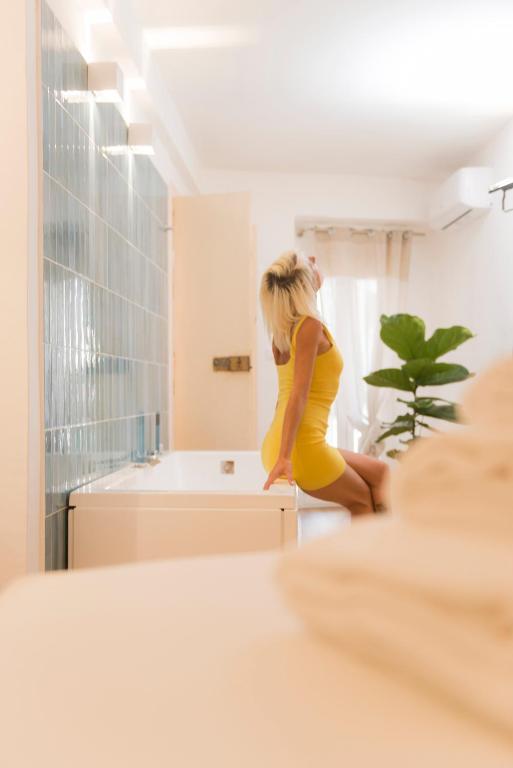 a woman in a yellow dress standing in a kitchen at ALMAMI Loft & Rooms in Monopoli