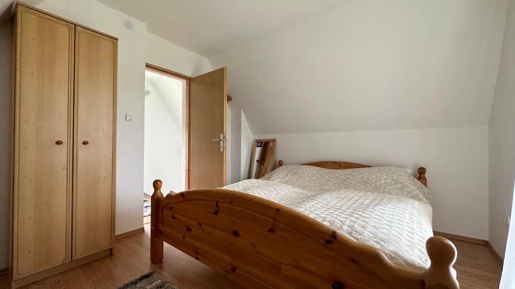 een slaapkamer met een houten bed en een houten kast bij B&B Hills Bihać in Bihać