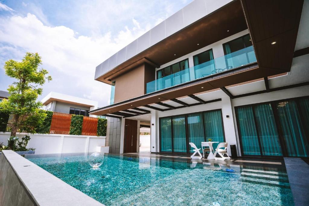 a swimming pool in front of a house at Minho Villa Luxury Pattaya in Nong Prue
