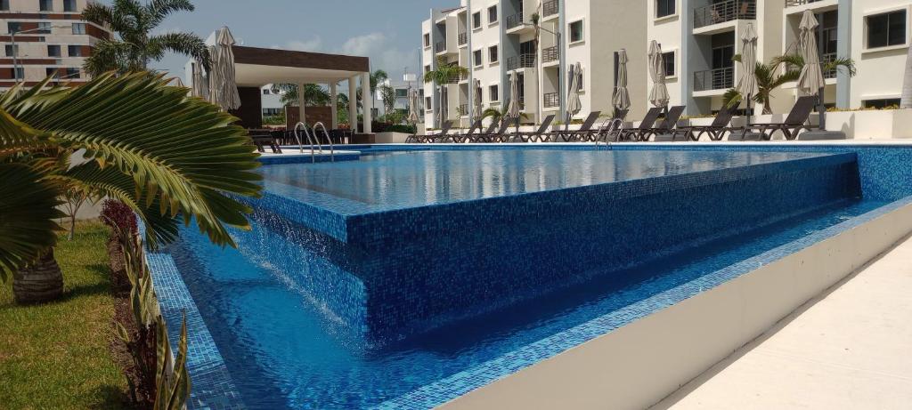 カンクンにあるExcellent 2 bedroom condo with pool!の一部の建物の前にある青いスイミングプール