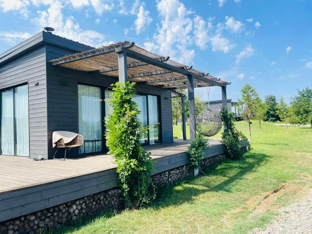 a house with a wooden deck with a pergola at 7 Lakes in Tʼelavi