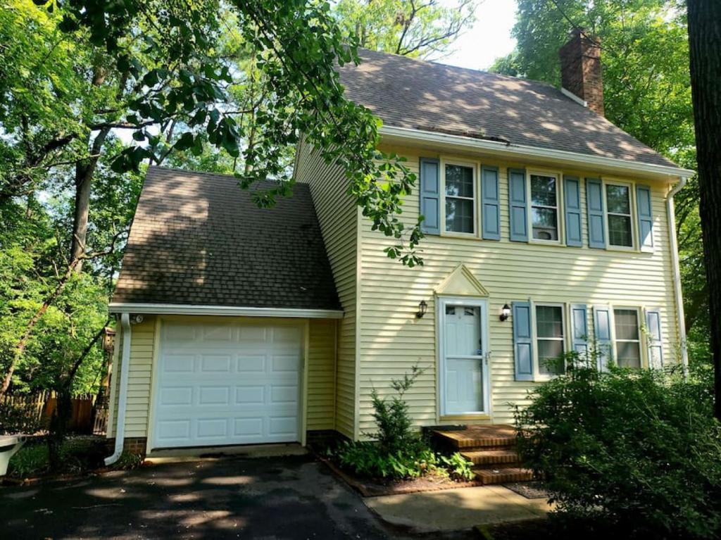 a yellow house with a white garage at 4-Bedroom House Close to Beach in Salisbury