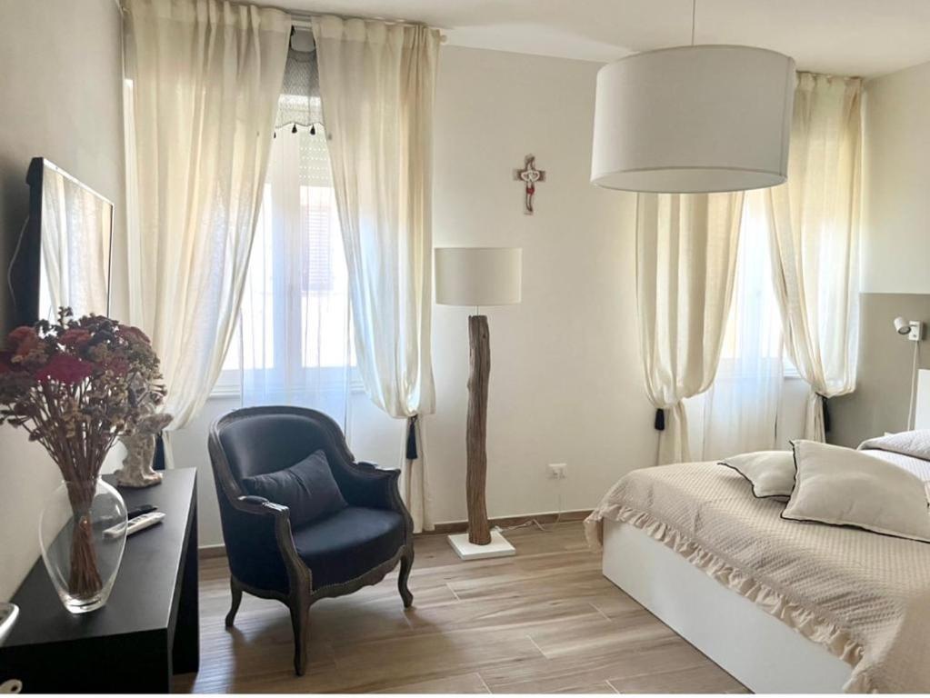 1 dormitorio con silla azul, 1 cama y escritorio en COROS - AFFITTI BREVI FUCECCHIO, en Fucecchio