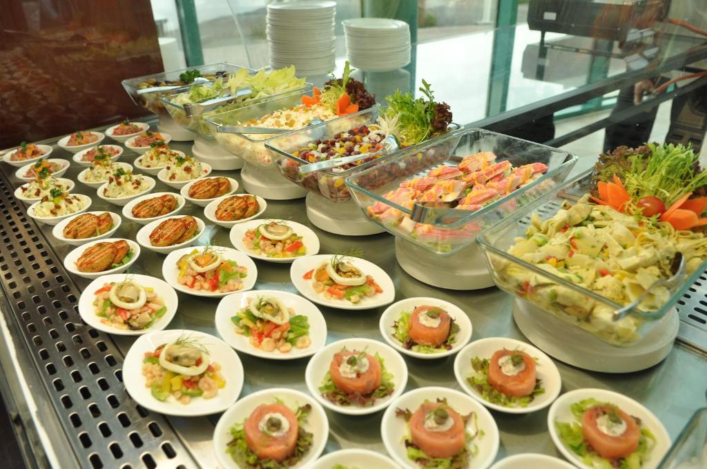 a buffet with plates of food on a table at Mirfa Hotel in Al Mirfa