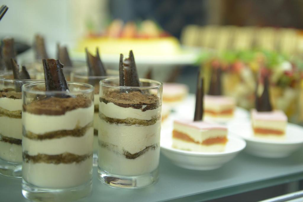 a group of desserts in glasses on a table at Mirfa Hotel in Al Mirfa