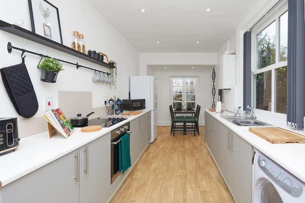 a kitchen with white counters and white counter tops at Timeless Elegance 4-Bed Victorian Charm in Leicester