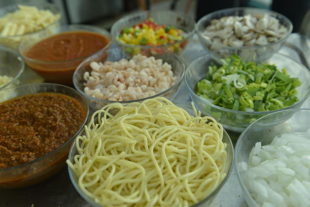 a table topped with bowls of different types of food at Mirfa Hotel in Al Mirfa