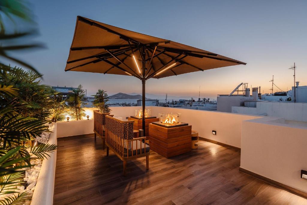 uma varanda com uma mesa e um guarda-chuva em Legato Spa Suites em Naxos Chora