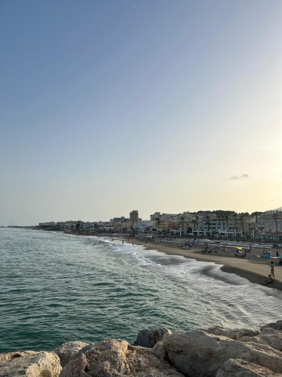 een strand met een groep mensen op het strand bij Fuengirola Sweet Apartament in Fuengirola