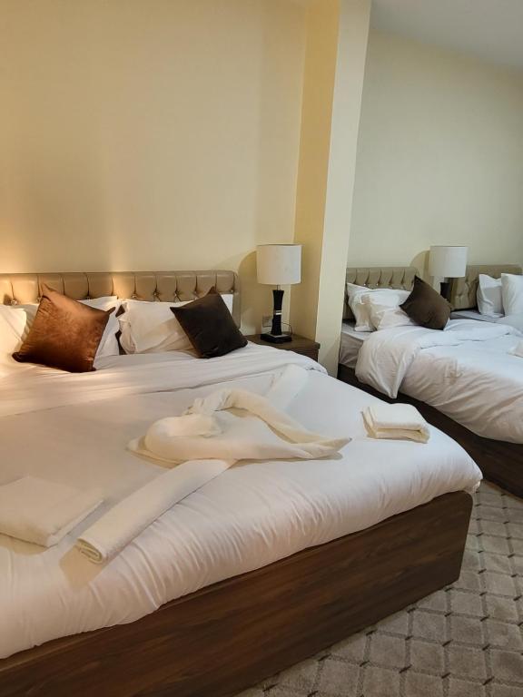2 łóżka w pokoju z białymi ręcznikami w obiekcie Petra Hill w mieście Wadi Musa