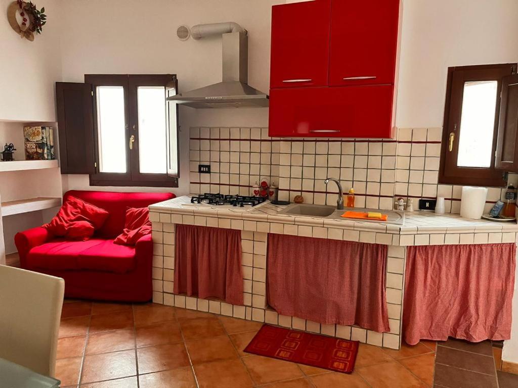 een keuken met rode kasten en een rode bank bij Borgo Mauro in SantʼArcangelo