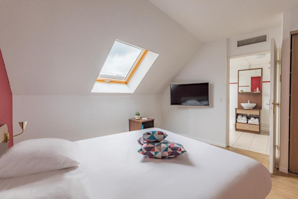 a bedroom with a large white bed with a window at Appart&#39;City Confort Pau Centre in Pau