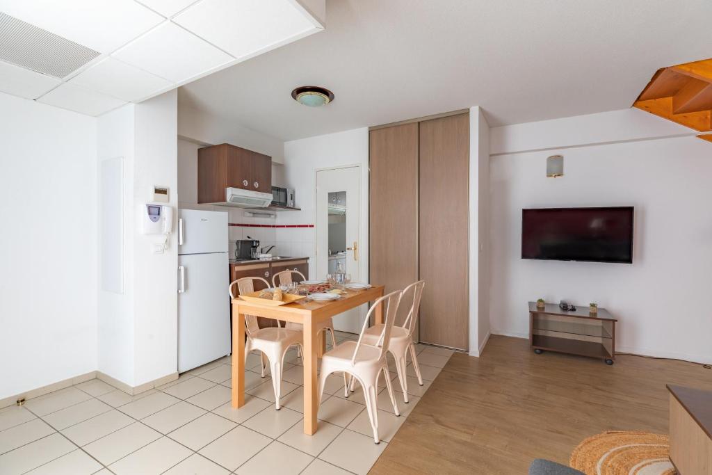 a kitchen and dining room with a table and chairs at Appart&#39;City Confort Pau Centre in Pau