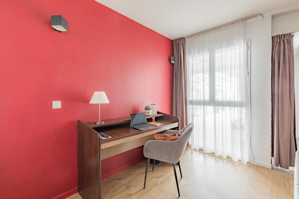 a red room with a desk and a chair at Appart&#39;City Confort Pau Centre in Pau