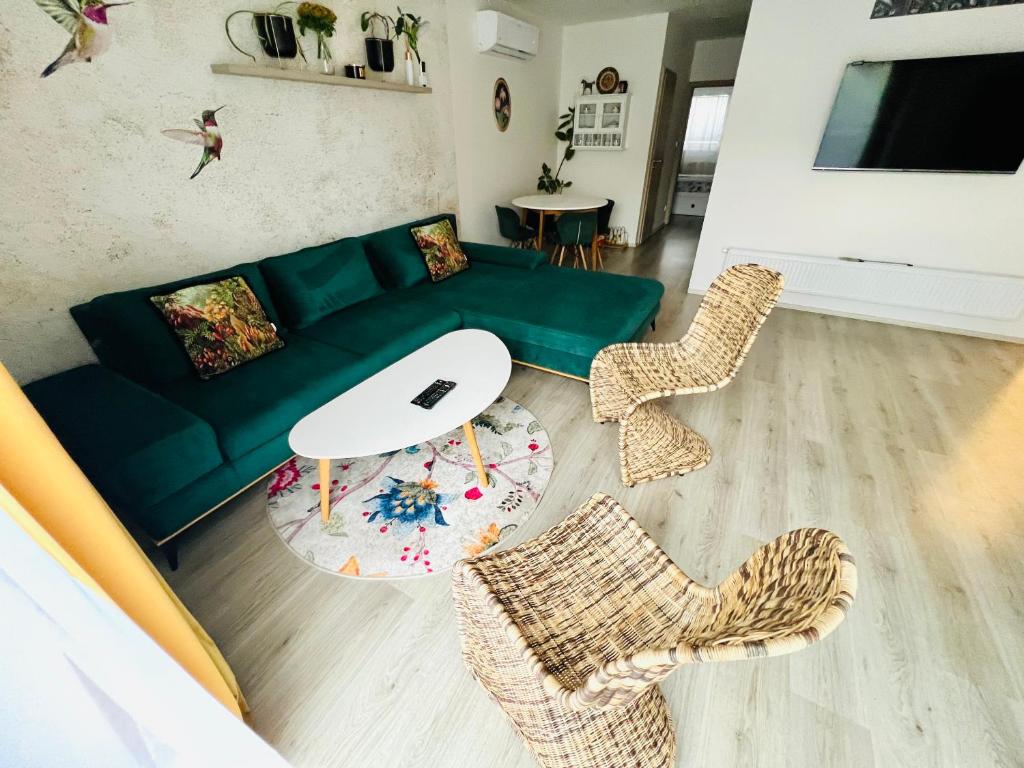 uma sala de estar com um sofá verde e cadeiras em Ubytování Hrušky em Hrušky