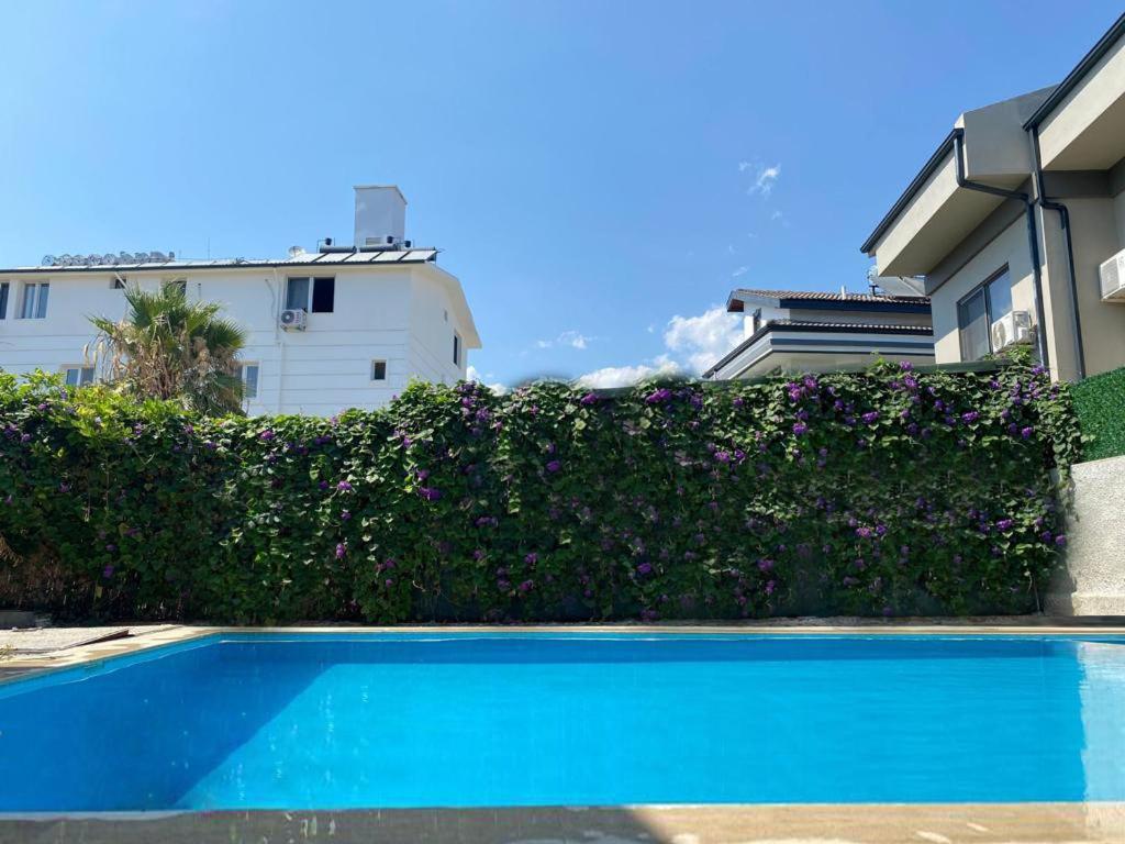 une piscine bleue en face d'un bâtiment dans l'établissement enjoy hotel, à Fethiye