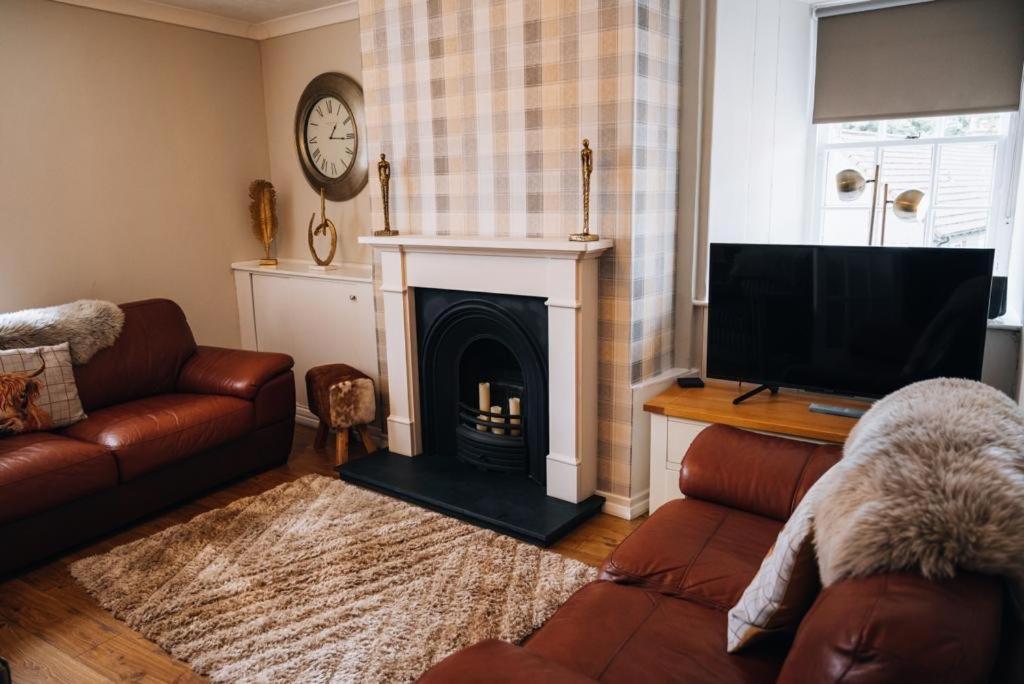 a living room with a couch and a fireplace at Menstrie Castle Stay in Stirling