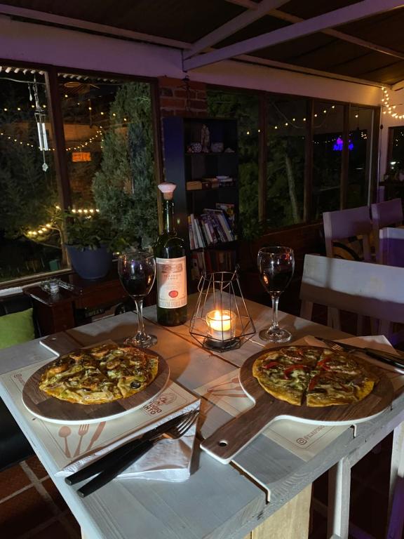 two pizzas sitting on a table with glasses of wine at El Refugio del Santo 