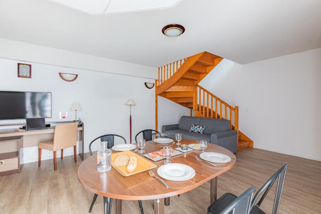 a dining room with a table and a couch at Appart&#39;City Confort Pau Centre in Pau