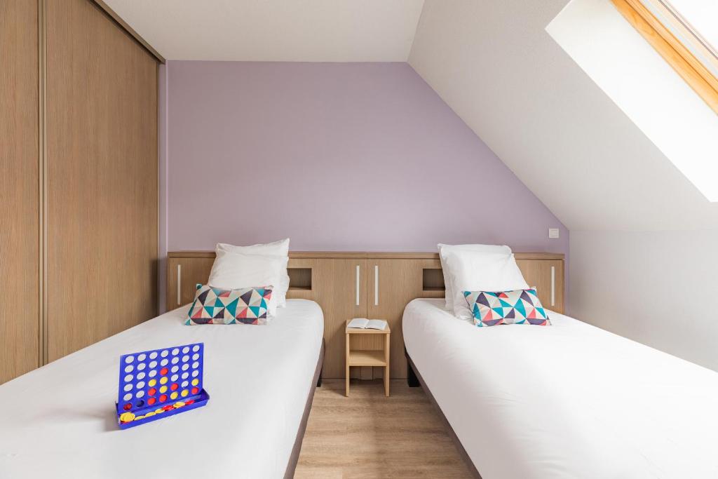 two beds in a small room with a board game at Appart&#39;City Confort Pau Centre in Pau