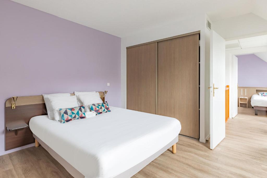 a white bedroom with a large white bed and a closet at Appart&#39;City Confort Pau Centre in Pau