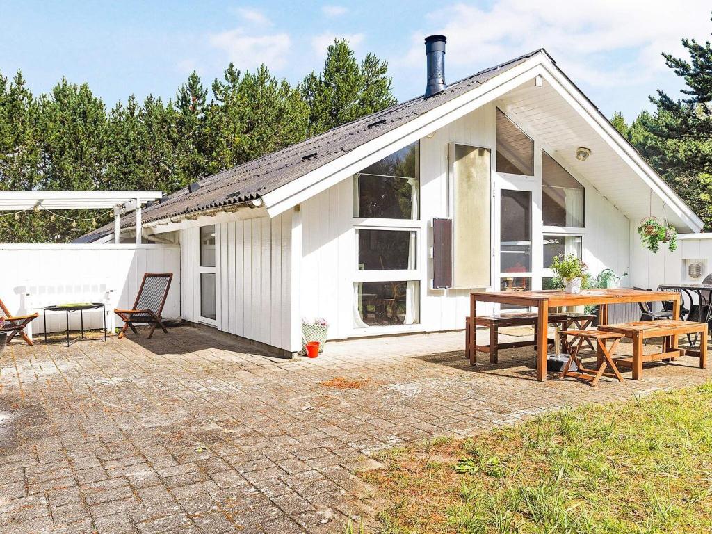 a white house with a patio and a table at Luxurious Retreat by Bratten Strand-By Traum in Jerup