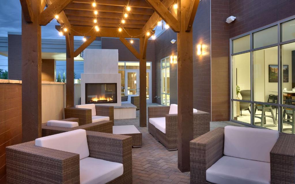 an outdoor patio with wicker chairs and a fireplace at Hilton Garden Inn Boise Downtown in Boise
